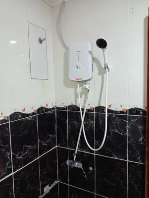 a bathroom with a hair dryer on the wall at HOTEL SAHARA INN TANJUNG MALIM in Kampong Chabang
