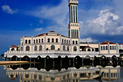 a large white building with a clock tower on top at EEs Whale House - Homestay 3 min walk to beach in Batu Ferringhi