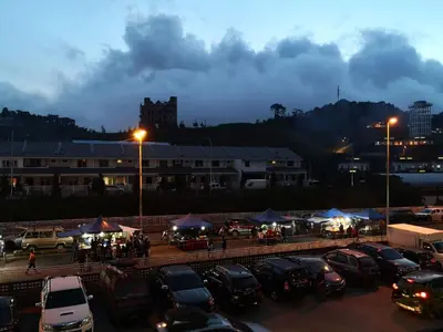 a parking lot with cars parked in front of a building at Lily Homestay Barrington Square Cameron Highlands. in Brinchang