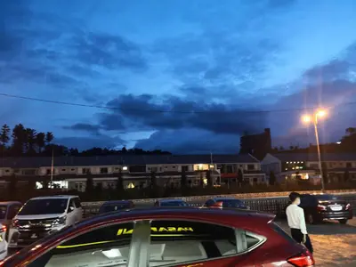 a group of cars parked in a parking lot at night at Lily Homestay Barrington Square Cameron Highlands. in Brinchang