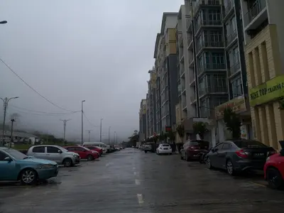a row of cars parked on a city street at Lily Homestay Barrington Square Cameron Highlands. in Brinchang