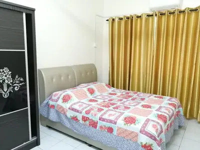 a bedroom with a bed with a quilt on it at YITOM Homestay\u6613\u901a\u6c11\u5bbf in Sungai Besar