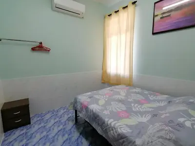 a bedroom with a bed and a dresser and a window at Mui Gim Homestay \u5927\u6e2f \u7f8e\u666f\u6c11\u5bbf in Sungai Besar