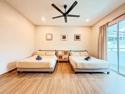 two beds in a room with a ceiling fan at Golden Sweet Home @ Golden Hills (Night Market, \u591c\u5e02) in Tanah Rata