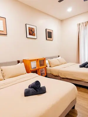 a room with two beds with towels on them at Golden Sweet Home @ Golden Hills (Night Market, \u591c\u5e02) in Tanah Rata