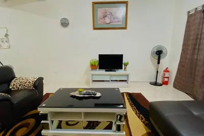 a living room with a couch and a table at LILY VACATION HOME at CAMERON HIGHLANDS - 12 PAX,FREE WiFi w CARPORCH in Tanah Rata