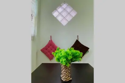 a vase with a plant on a table with pillows at LILY VACATION HOME at CAMERON HIGHLANDS - 12 PAX,FREE WiFi w CARPORCH in Tanah Rata