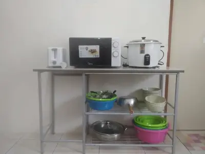a shelf with pots and pans and a microwave at LILY VACATION HOME at CAMERON HIGHLANDS - 12 PAX,FREE WiFi w CARPORCH in Tanah Rata