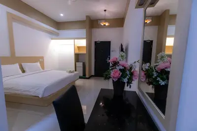 a bedroom with a bed and flowers on a table at Scott Service Suites in George Town