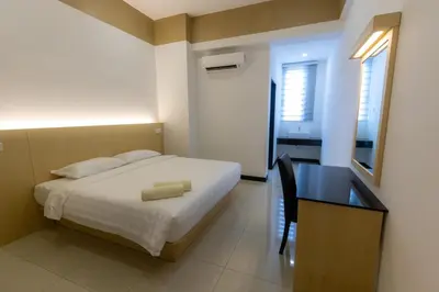 a bedroom with a bed and a desk and a table and a bed at Scott Service Suites in George Town