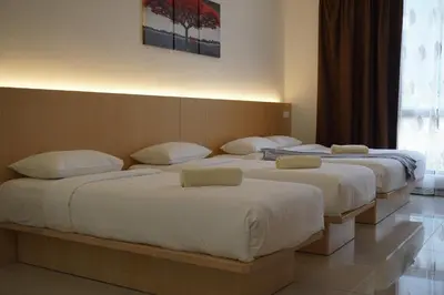 a group of three beds in a room at Scott Service Suites in George Town