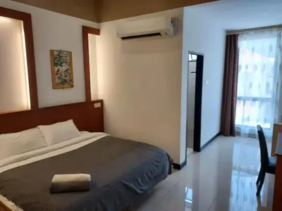 a bedroom with a bed and a table and a window at Scott Service Suites in George Town
