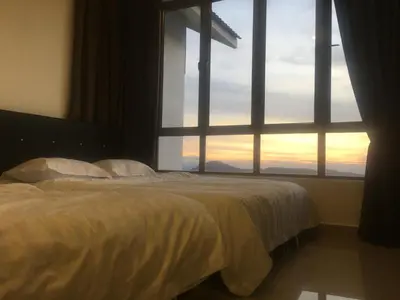 a bedroom with a bed and a large window at Relax Bear Homestay in Tanah Rata