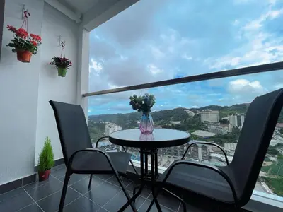 a table and chairs in a room with a window at Relax Bear Homestay in Tanah Rata