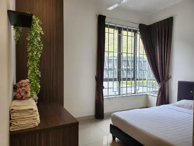 a bedroom with a bed and a large window at Relax Bear Homestay in Tanah Rata