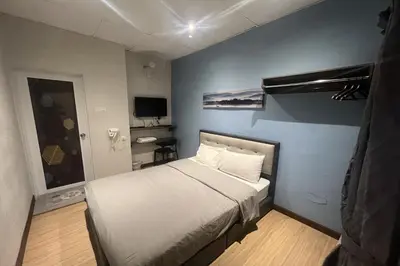 a small bedroom with a bed and a television at Moon Hotel, Cameron Highlands in Brinchang