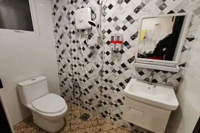 a bathroom with a toilet and a sink and a mirror at Moon Hotel, Cameron Highlands in Brinchang