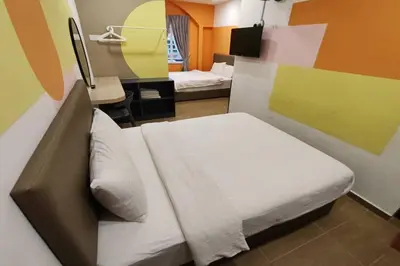 a bedroom with a bed and a desk with a mirror at Moon Hotel, Cameron Highlands in Brinchang