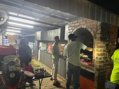 a group of people preparing food in a brick oven at Branda Kampung Sumpitan Lenggong TIADA SUNGAI in Kampong Ulu Jepai