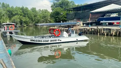a boat is docked at a dock in the water at Branda Kampung Sumpitan Lenggong TIADA SUNGAI in Kampong Ulu Jepai
