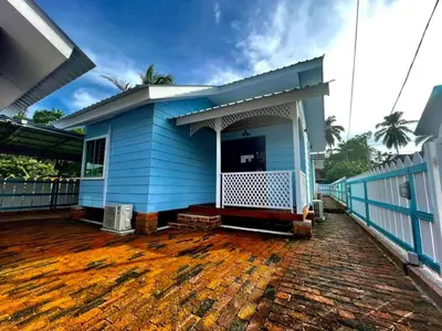 a blue house with a porch on a brick patio at Branda Kampung Sumpitan Lenggong TIADA SUNGAI in Kampong Ulu Jepai
