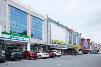 a city street with cars parked in front of buildings at East Sun Hotel Sekinchan in Sekincan