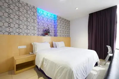 a bedroom with a white bed and a colorful wall at East Sun Hotel Sekinchan in Sekincan
