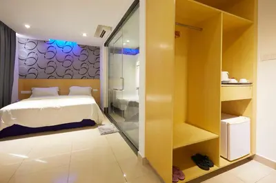 a bedroom with a bed and a glass shower at East Sun Hotel Sekinchan in Sekincan
