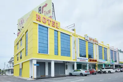 a yellow building with cars parked in front of it at East Sun Hotel Sekinchan in Sekincan