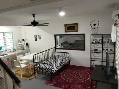 a bedroom with a bed and a table and a mirror at lost world of tambun homestay in Ipoh