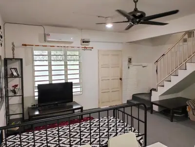 a living room with a ceiling fan and a flat screen tv at lost world of tambun homestay in Ipoh