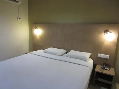 a bedroom with a large white bed with two pillows at Radiant Hotel in Sitiawan