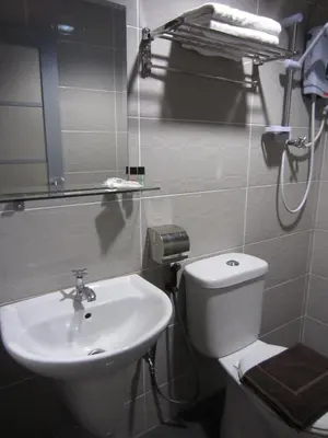 a bathroom with a white toilet and a sink at Radiant Hotel in Sitiawan