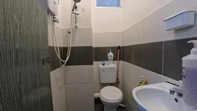 a bathroom with a shower and a toilet and a sink at Fizan Homestay in Tanah Rata