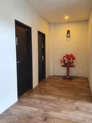a hallway with two doors and a table with flowers at See Foo Hotel in Bidur