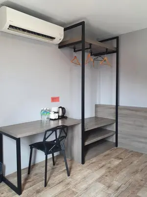 a room with a desk and a bed with a fan at See Foo Hotel in Bidur