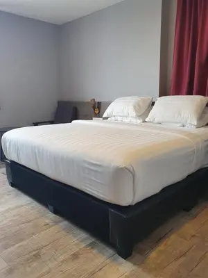 a large bed with white sheets and pillows on it at See Foo Hotel in Bidur