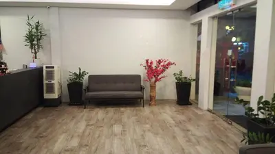 a waiting room with a chair and flowers in a building at See Foo Hotel in Bidur
