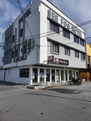a white building with a motorcycle parked in front of it at See Foo Hotel in Bidur