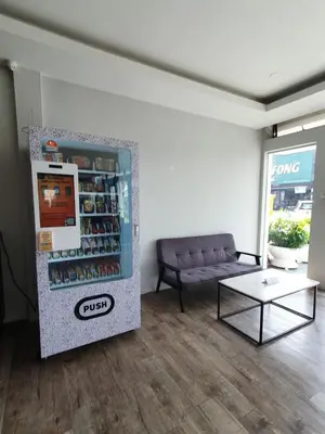 a living room with a couch and a drink refrigerator at See Foo Hotel in Bidur