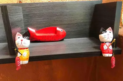 two toy cats sitting on a wooden shelf at Tambun homestay in Ipoh