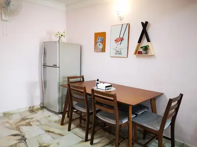 a dining room with a table and a refrigerator at Taman Bagan Single Storey Terrace House, 9mins to Sunway Carnival Mall, Seberang Jaya in Butterworth
