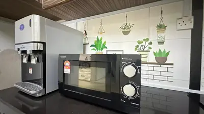 a microwave oven sitting on a counter in a kitchen at Taman Bagan Single Storey Terrace House, 9mins to Sunway Carnival Mall, Seberang Jaya in Butterworth