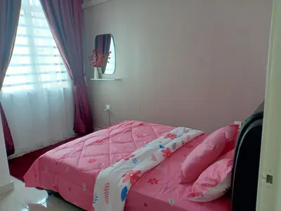 a bedroom with a bed with pink sheets and a window at As Syifaa Homestay Mslim only in Ipoh