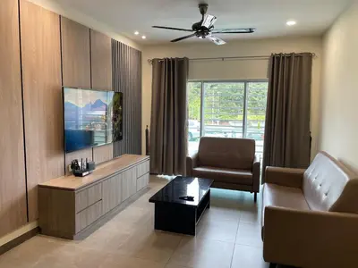 a living room with a couch and a tv at The Quintet Cameron Highlands by Tulip in Tanah Rata