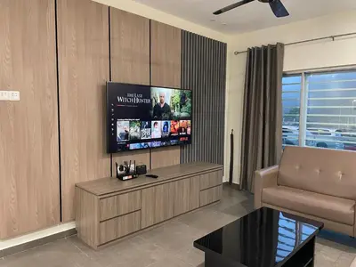 a living room with a couch and a flat screen tv at The Quintet Cameron Highlands by Tulip in Tanah Rata