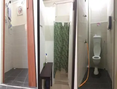 a bathroom with a shower and a toilet in a stall at We Love GuestHouse in George Town