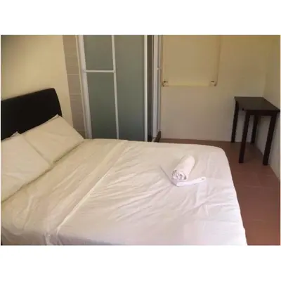 a white bed with a towel on top of it at We Love GuestHouse in George Town
