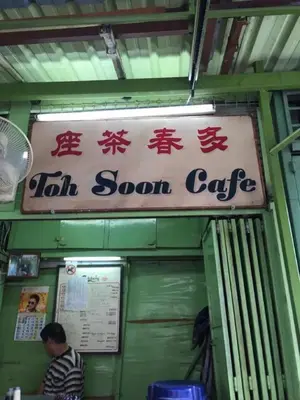 a sign for a tea room cafe with a man standing outside at We Love GuestHouse in George Town