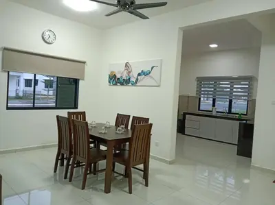 a dining room with a table and chairs and a kitchen at Pangkor Happy Villa @ 88 Resort Villa Riadah in Kampong Sungai Udang